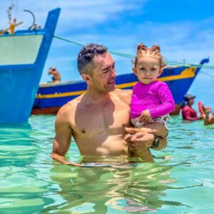 Pai e filha no colo nas piscinas naturais de picãozinho em joão pessoa na paraíba