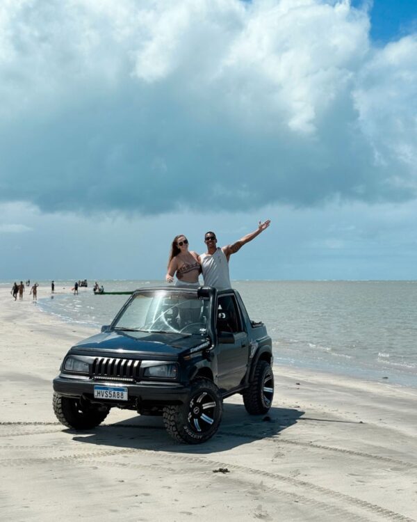 CASAL NA PRAIA SOBRE O CARRO